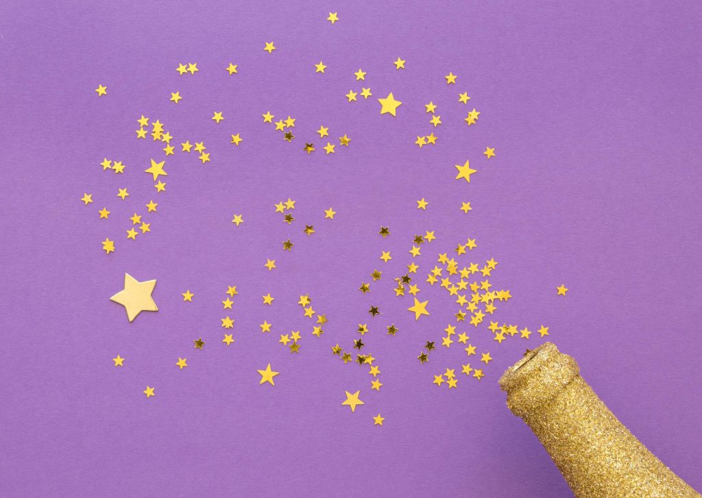 Photo de paillettes qui sortent d'une bouteille de champagne